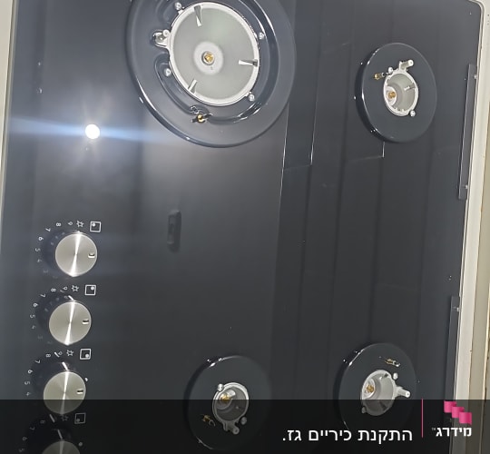 כיריים גז שחורים עם כפתורים בצד